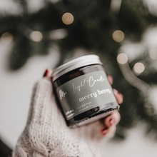 Kép betöltése a galériamegjelenítőbe: Merry Berry szójagyertya fa tálcán, friss szilvával és vaníliarúddal körülvéve, ünnepi hangulatú háttérrel.