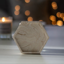 Kép betöltése a galériamegjelenítőbe: Hatszögletű bézs márványmintás jesmonite ásványgyanta alátét – stílusos és modern gyertyatartó tálka a More Light Candle kollekcióból.