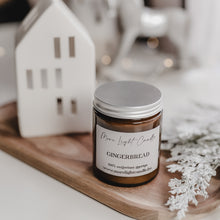 Kép betöltése a galériamegjelenítőbe: Kézzel öntött Gingerbread gyertya, mellette méz és gyömbér, ünnepi háttérfénnyel.