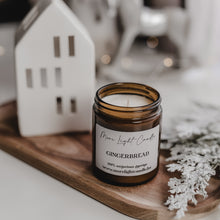 Kép betöltése a galériamegjelenítőbe: Kézzel öntött Gingerbread gyertya, mellette méz és gyömbér, ünnepi háttérfénnyel.