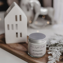 Kép betöltése a galériamegjelenítőbe: Nutcracker gyertya ámbra üvegben, ezüst tetővel, téli hangulatú környezetben, fa tálcán elhelyezve.