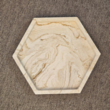 Kép betöltése a galériamegjelenítőbe: Hatszögletű bézs márványmintás jesmonite ásványgyanta alátét – stílusos és modern gyertyatartó tálka a More Light Candle kollekcióból.