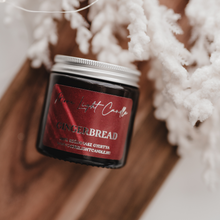 Kép betöltése a galériamegjelenítőbe: Kézzel öntött Gingerbread gyertya, mellette méz és gyömbér, ünnepi háttérfénnyel.