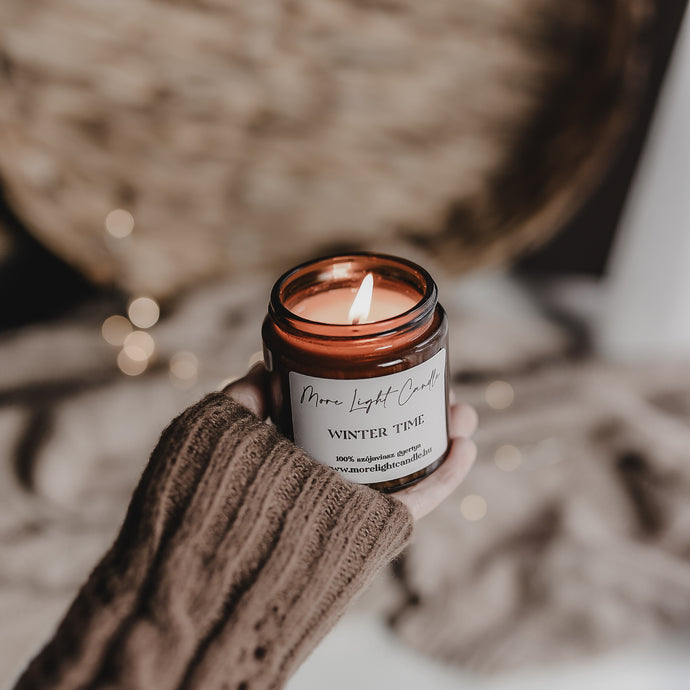 Kézzel öntött Winter Time gyertya ezüst tetővel, mellette friss körte és vörösáfonya, havas dekorációban.